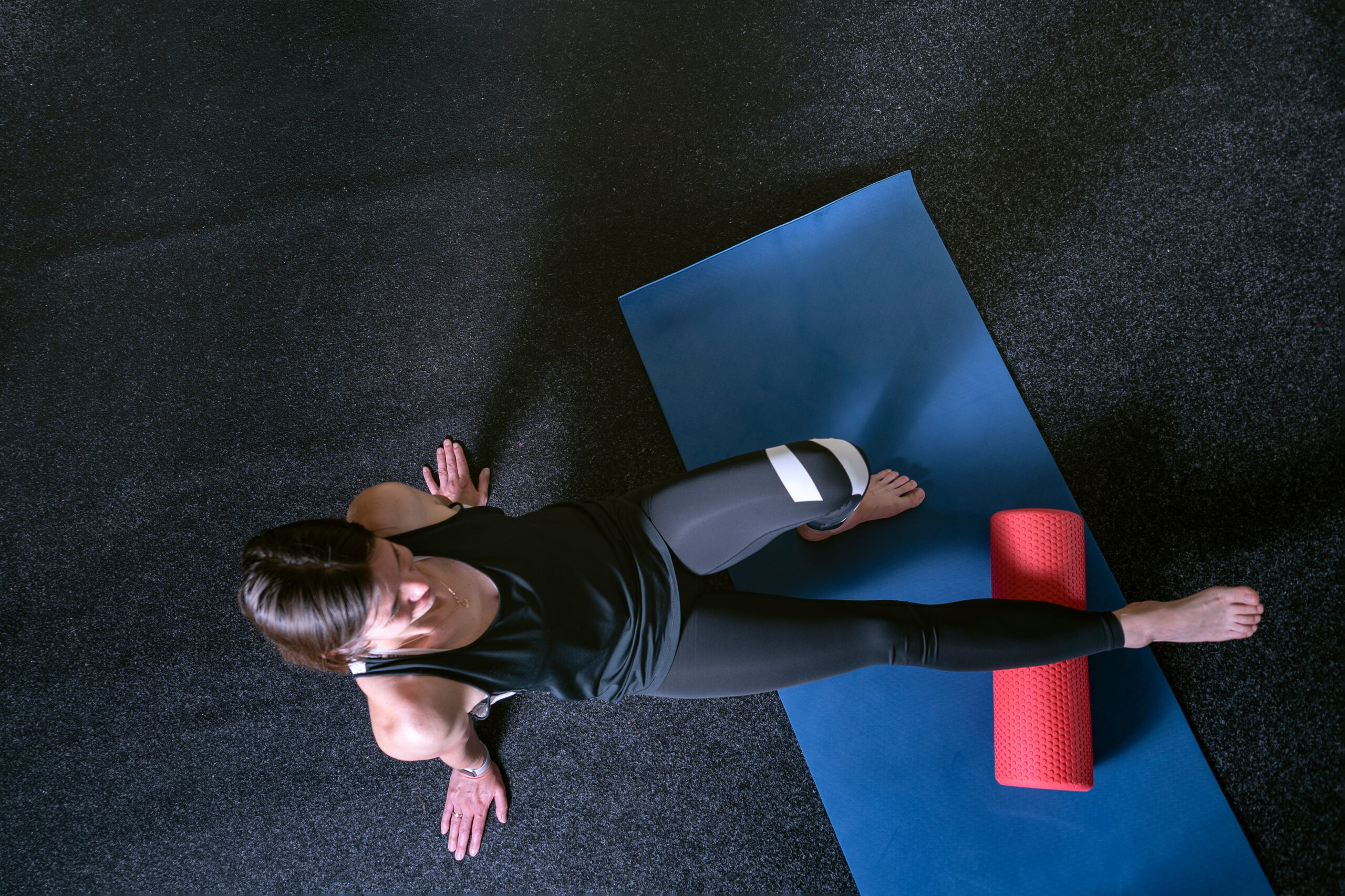 Athlete kneads the muscles of the legs with MFR roller. Top view. Roller to roll out calf muscles
